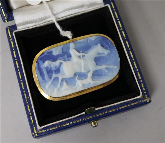 An Italian 18ct gold mounted blue jasper brooch carved with horse and rider in hunting scene, 49mm.